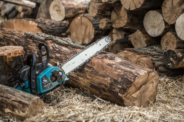 Man chopping wood with a chainsaw ,close-up